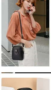 Détails du sac à bandoulière en cuir grainé noir avec boucle brune et sangle fine