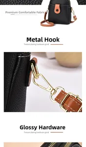 Detail view of black litchi pattern mini crossbody bag with gold-tone hardware and brown strap