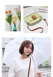 Detail of light green small crossbody bag with double zippers and brown leather strap