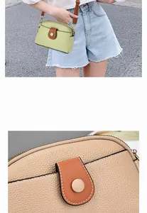 Detail of lychee pattern leather crossbody bag with contrast buckle and adjustable strap