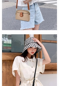 Detail of a beige pebbled leather crossbody bag paired with a plaid bucket hat and denim