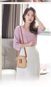 Detailed view of beige crossbody phone bag with lychee texture and brown shoulder strap