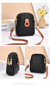 Detailed views of small black lychee grain crossbody bag with brown straps and gold zippers