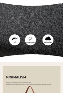 Detail of soft black litchi grain leather texture and brown handle on a mini crossbody bag