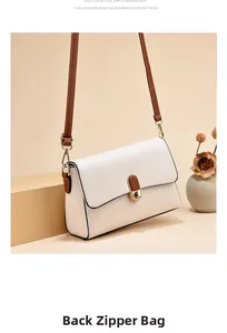 Detail view of the back zipper pocket on this off-white crossbody bag with brown strap