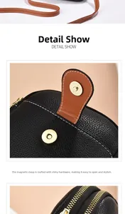 Detail of black litchi leather bag with brown oil edge strap and gold magnetic clasp