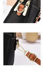 Detail of black litchi leather bag with gold hardware and white stitching accents