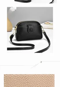 Detailed macro of black pebble leather bag with white contrast stitching and gold zippers