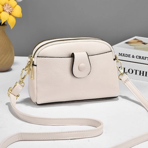 Cream lychee leather crossbody bag for women with gold hardware and dual zipper pockets