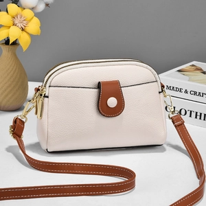 Chic beige lychee grain shoulder bag with brown trim and gold hardware in a set scene