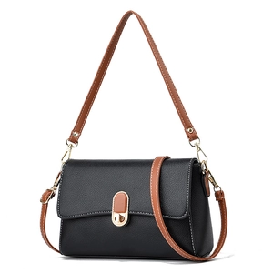 Minimalist black leather crossbody bag with brown strap and golden turn-lock closure