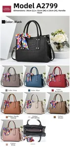 Detailed view of crocodile texture handbag with floral silk scarf on dual handles
