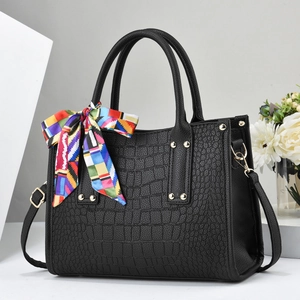 Elegant black crocodile pattern tote bag with gold hardware and decorative scarf accent