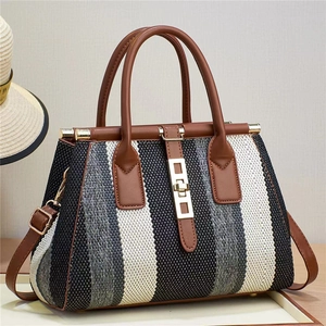 Detailed macro view of woven textured handbag with elegant gold metal lock and leather strap
