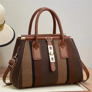 Close-up of the vertical striped woven fabric and golden metal buckle on the leather tote bag