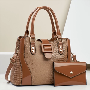 Detail of caramel brown croc-embossed tote bag and matching envelope wallet set