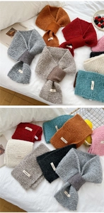 Detail of soft knit neck warmer showing textured yarn and crossover buckle structure