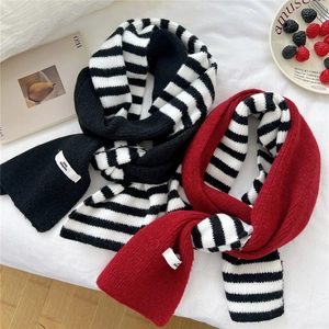 Striped knit scarves in black and red with brand labels on a cozy white background