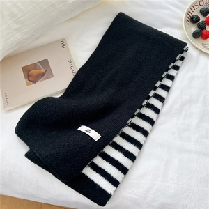 Detail of a thick knitted scarf showing the double-sided black and white striped pattern