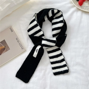 Detail of black and white striped chunky knit scarf with pink dolphin brand woven label