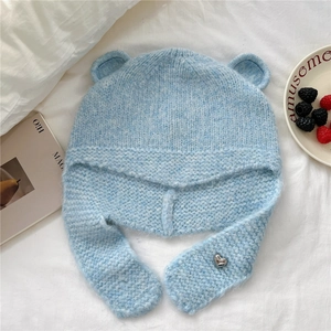 Gros plan sur le bonnet en tricot bleu clair avec oreilles d'ours et cœur argenté