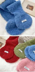 Detailansicht weicher Bouclé-Strickschals in leuchtenden Farben mit Logo-Etiketten