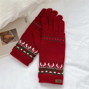 Detailed close-up of red Christmas knit gloves with reindeer and snowflake patterns
