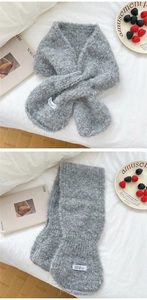 Nahaufnahme eines weichen grauen Strickschals mit flauschiger Textur und modischem Stoffetikett