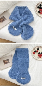 Detail eines weichen blauen Strickschals mit weißem Webetikett auf flauschiger Textur