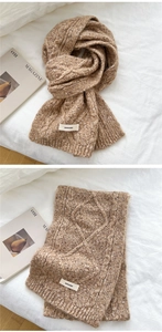 Macro detail of brown cable-knit scarf featuring vintage textured yarn and woven brand label
