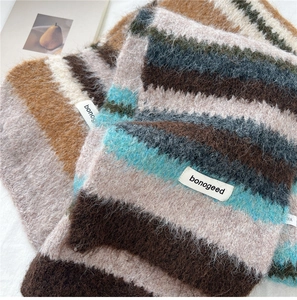 Close-up detail of soft striped knit scarf featuring plush texture and woven brand label