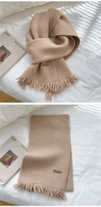Detailed knit texture and Hand Made leather label on light camel tassel scarf