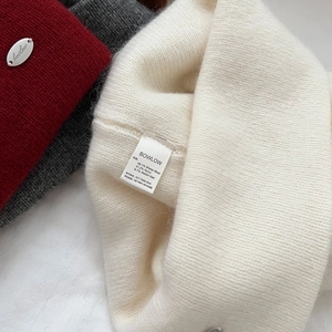 Detail of wool blend knit texture and metallic logo on premium winter beanie caps