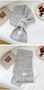 Close-up of grey knit scarf with cross-over slit design and ins woven label detail