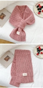 Close-up of pink knit scarf showing thick stitching texture and white ins woven label
