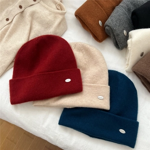 Solid knit beanie hats for women in various colors with elegant metal logo detail