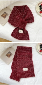 Detail of red knit criss-cross neck warmer with ins label and ribbed texture