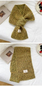 Detail of moss green chunky knit scarf with ins label in a cozy home setting