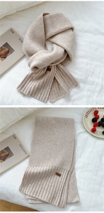 Detail of oatmeal knit scarf featuring soft ribbed edges and small decorative label