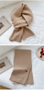 Close-up of beige knit scarf texture with leather brand logo and cozy ribbing detail