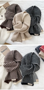 Detail shot of assorted striped knit scarves featuring minimalist woven brand labels