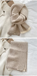 Detail of striped knit scarf with brand label paired with wool coat for winter outfit