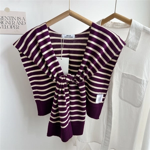 Détail de l'étiquette de marque sur un châle en tricot à rayures violet et beige