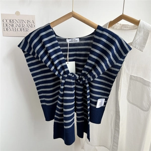 Détails du châle en tricot rayé bleu et gris avec un nœud décoratif élégant à l'avant