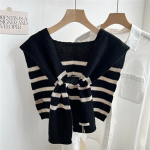 Détail d'un châle en laine tricotée à rayures noires et blanches sur une chemise