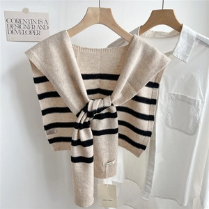Vue détaillée de l'étiquette 100% laine sur un châle en tricot rayé beige et noir
