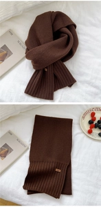 Detailed knit texture of dark coffee winter scarf with a small leather logo label