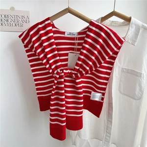 Gros plan d'un châle en tricot à rayures rouges et blanches avec étiquette de marque