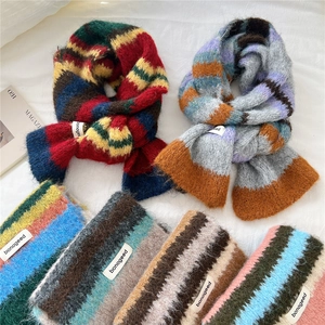 Colorful striped mohair knit scarf with fringe and brand label on white fabric background
