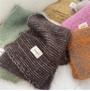 Close-up of soft knitted scarves in various colors with fuzzy mohair texture